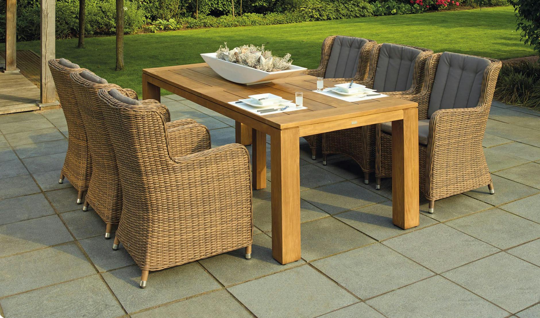 Outdoor Patio Furniture Setup for Entertaining Relaxing outdoor patio with rattan chairs and wooden table for outdoor entertaining