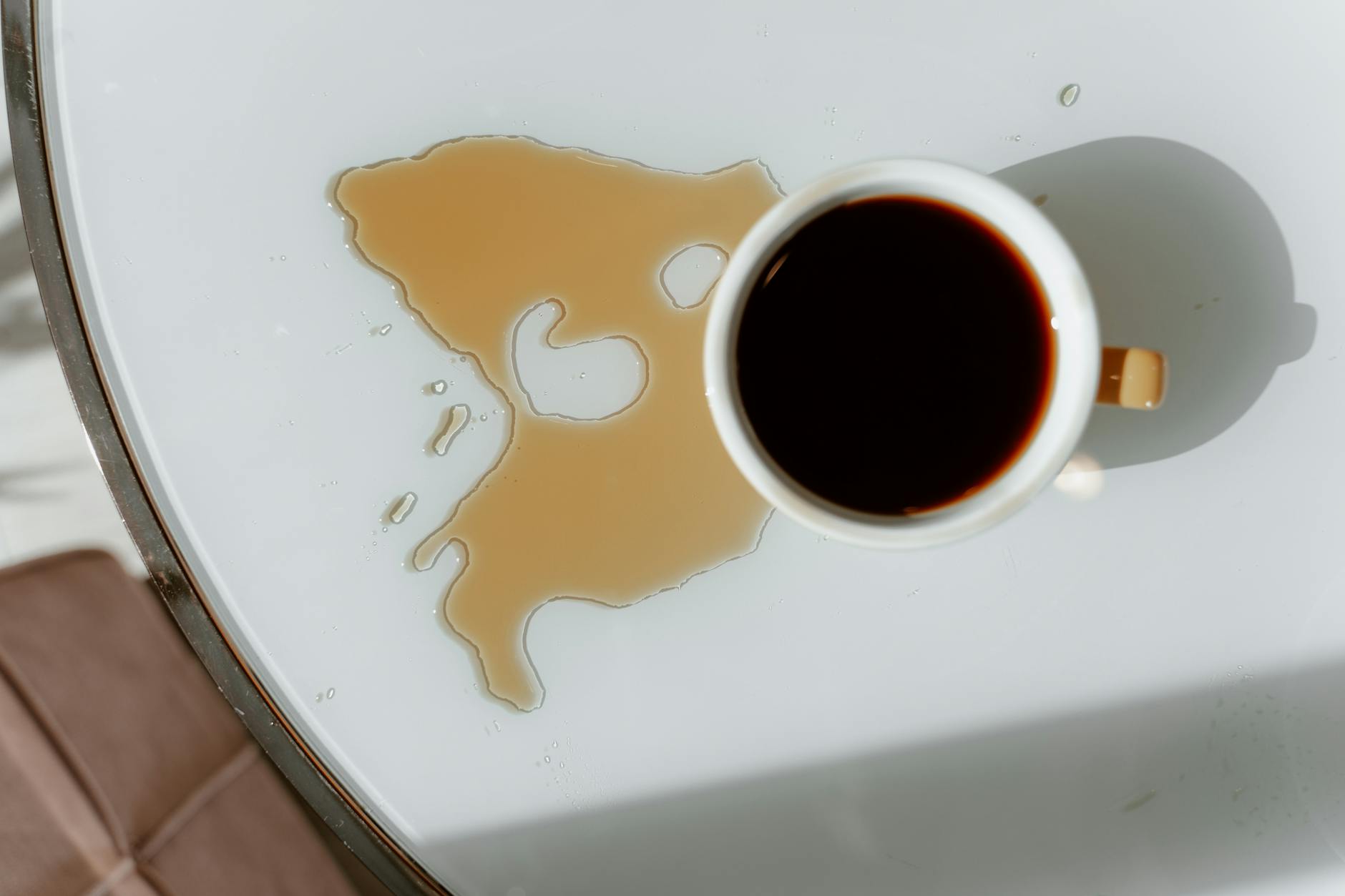 Coffee Spill — One of the Toughest Set-In Stains on Carpet Overhead view of a coffee cup spill — showing the kind of stain that becomes much harder to remove once dried