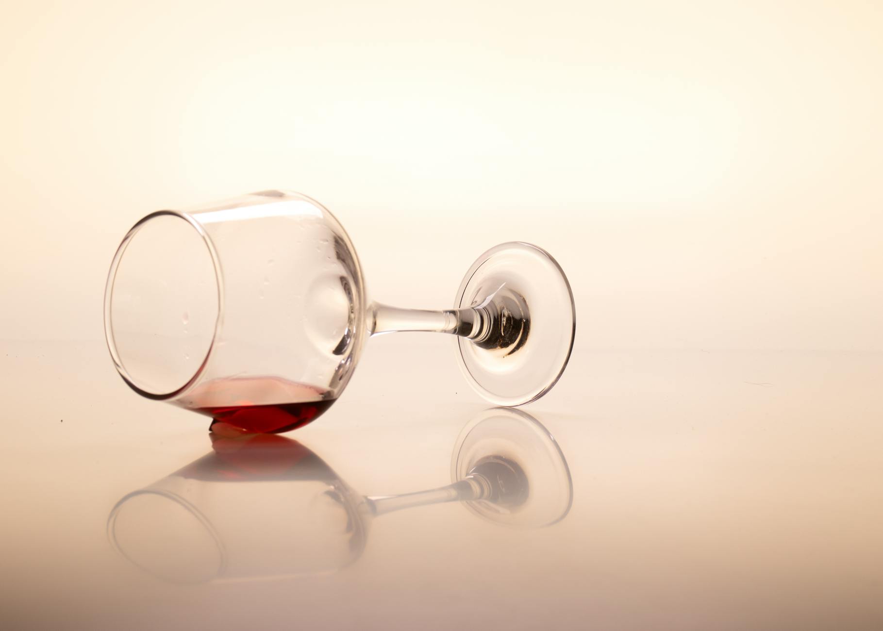 Red Wine Spill — A Classic Hard to Remove Carpet Stain Tipped red wine glass creating a spill — illustrating one of the most notorious hard to remove carpet stains