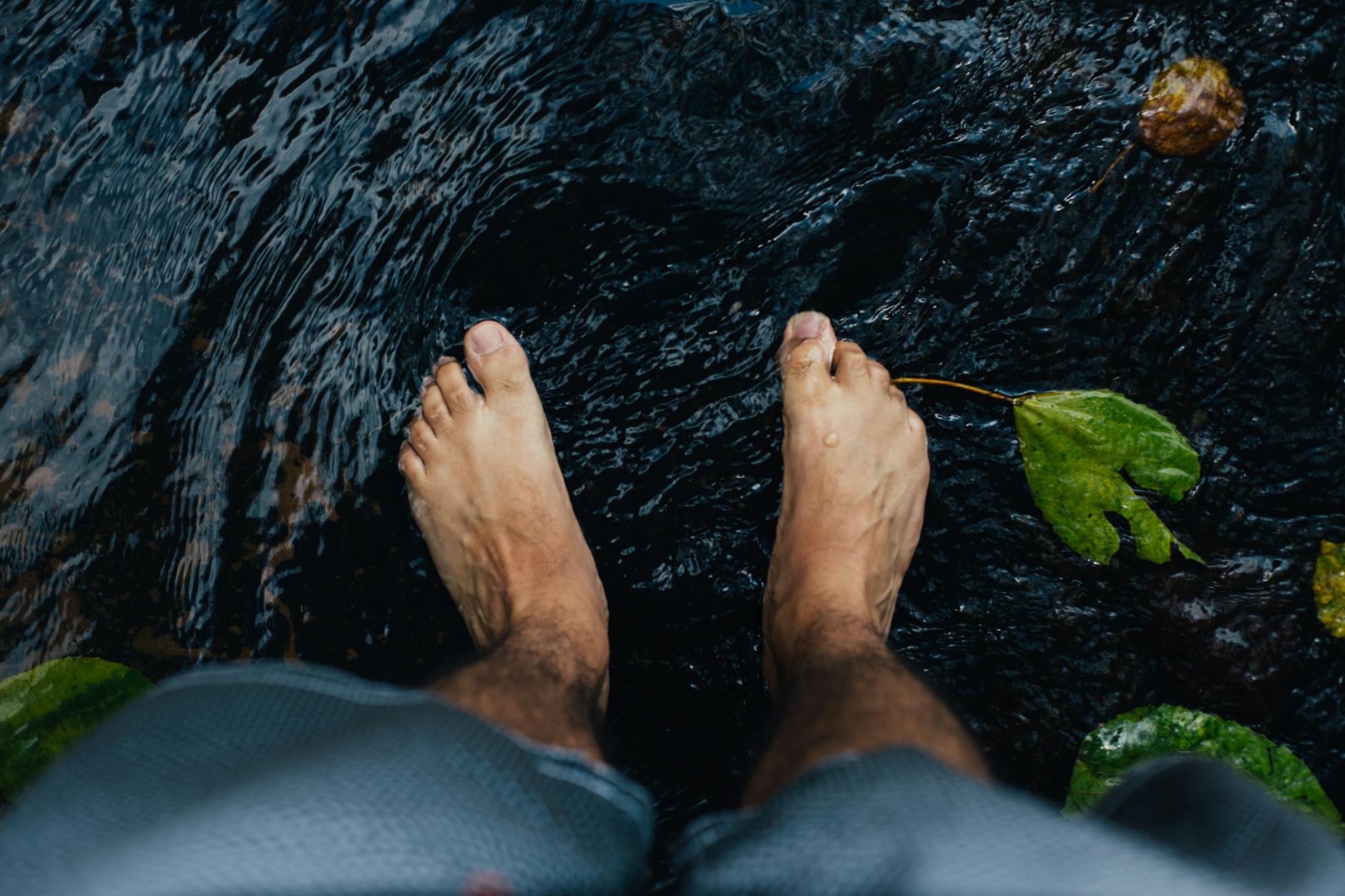 Foot Swelling and Circulation Health Close up of bare feet standing in flowing water, representing foot swelling and circulation