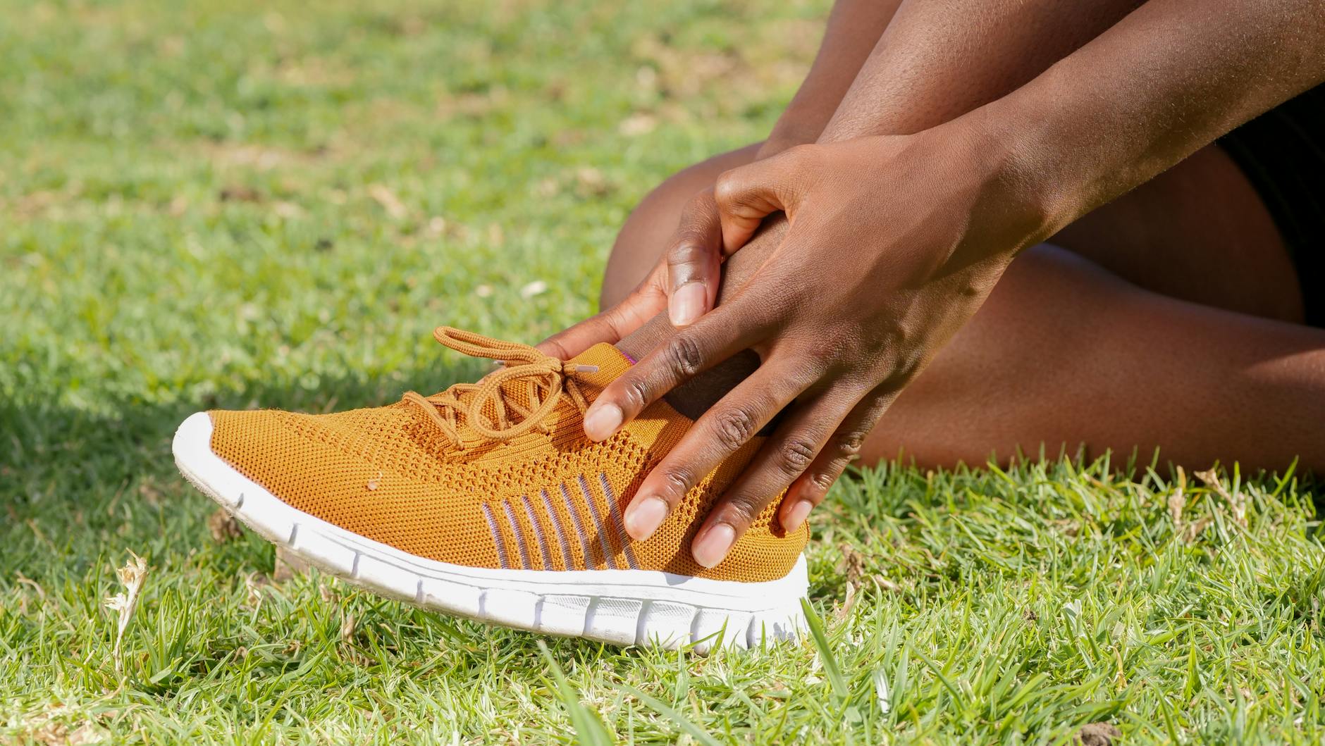 Foot and Ankle Pain Warning Signs Person holding ankle showing signs of foot pain and injury