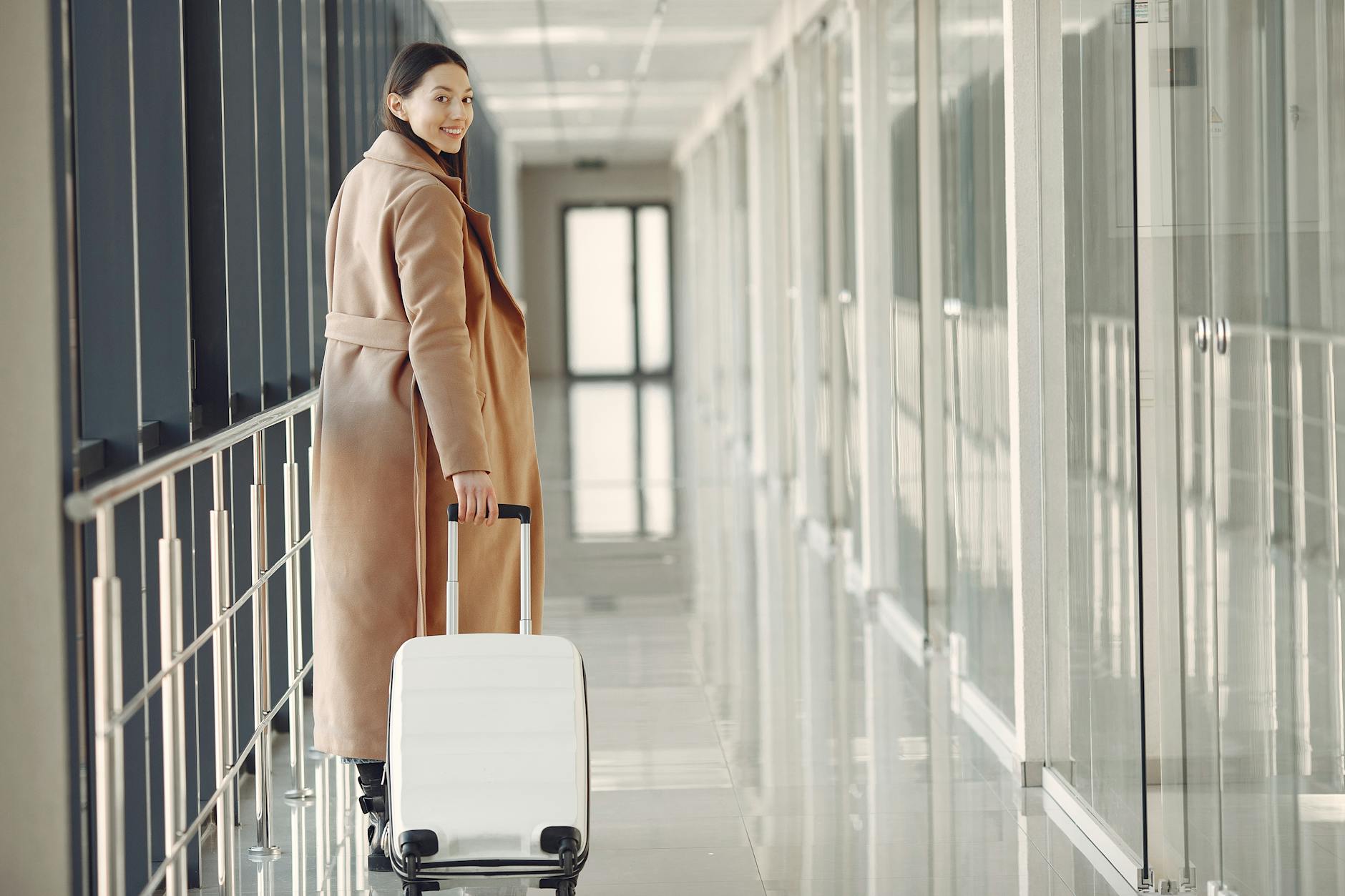 Confident Traveler at Airport Terminal Woman walking confidently through airport terminal with suitcase