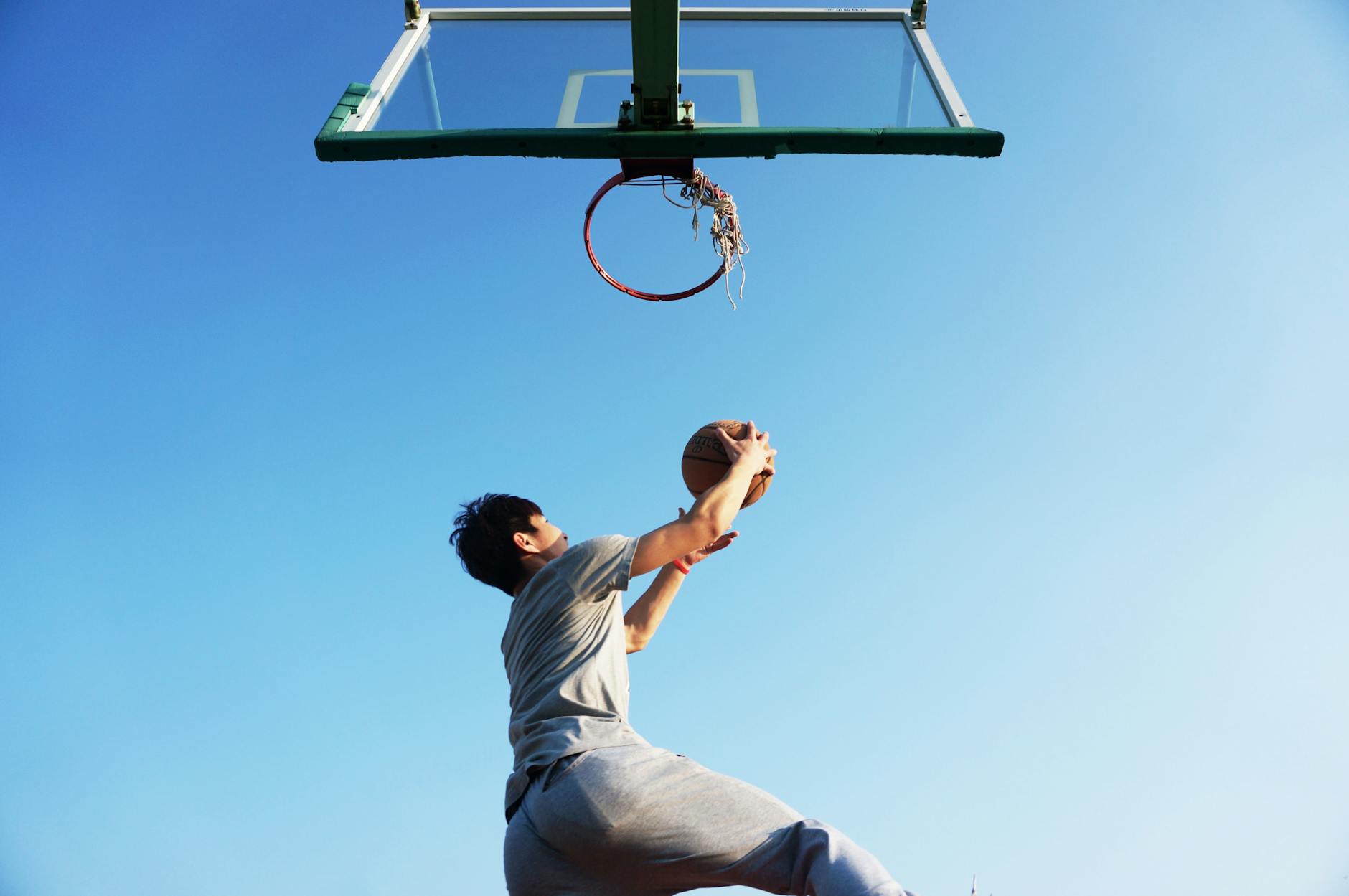 Basketball Jump Training and Explosiveness Drill Basketball player jumping explosively toward the hoop outdoors