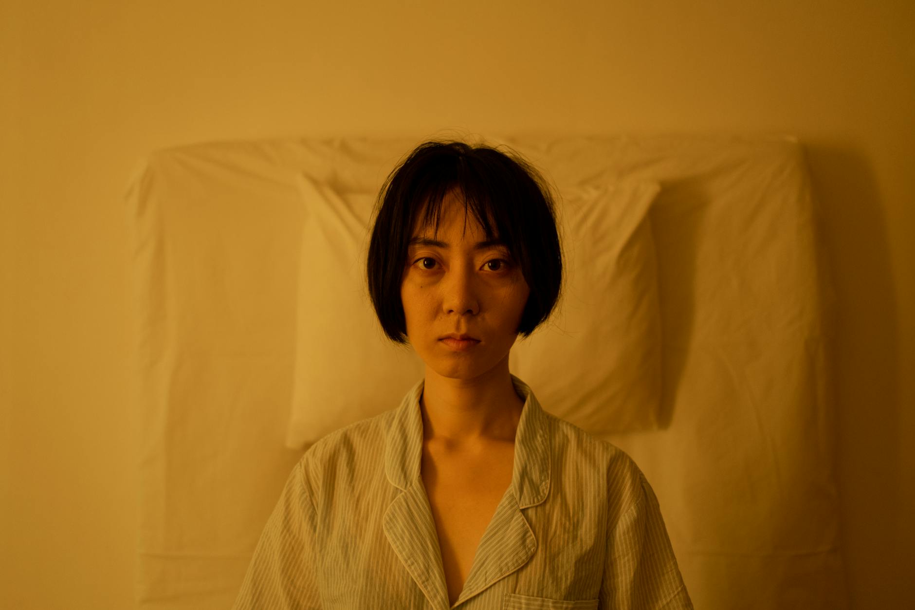 Nervous System and Sleep - Stress Preventing Rest at Night Woman sitting up in bed looking stressed and unable to sleep due to cortisol and nervous system activation