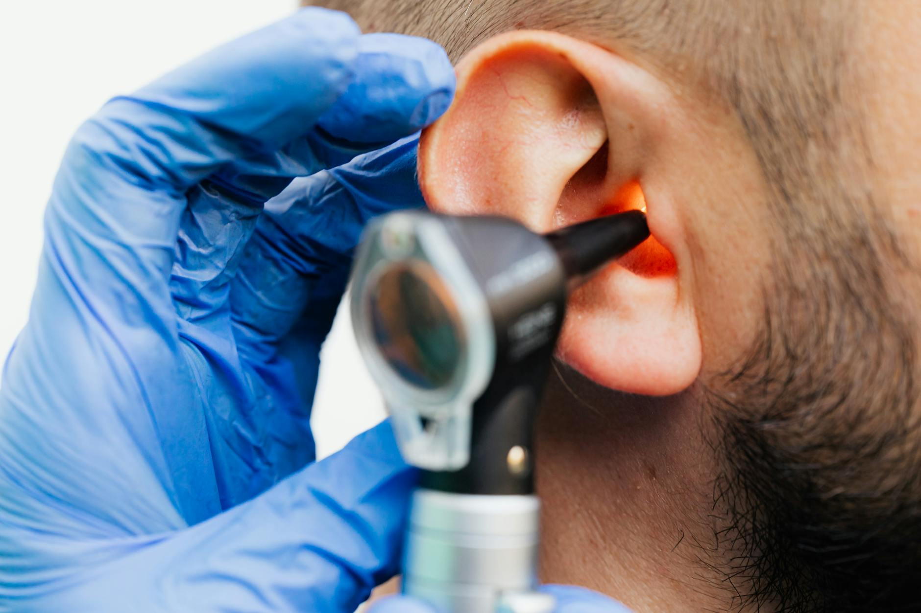 When to Get a Hearing Test — Professional Audiological Evaluation Doctor using an otoscope to examine a patient's ear in a clinical setting