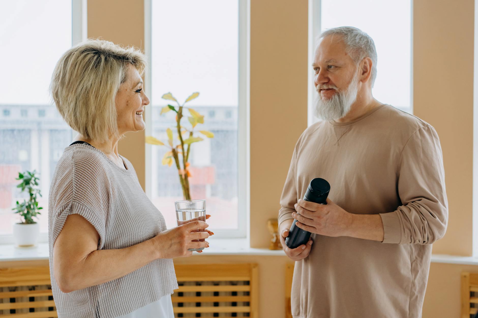 Communication Challenges as a Sign of Early Hearing Loss Senior couple smiling and talking together indoors