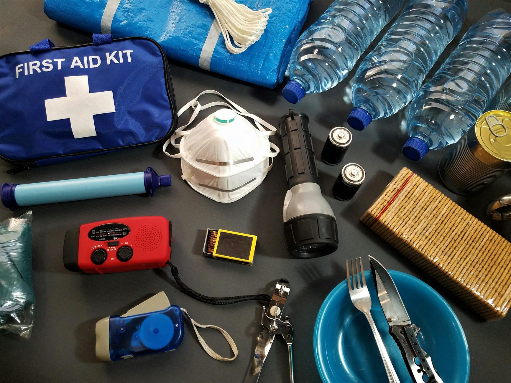 Emergency Supplies 72-Hour Kit - Water and Food Essentials Emergency survival kit with water bottles, food supplies, and essential items laid out flat