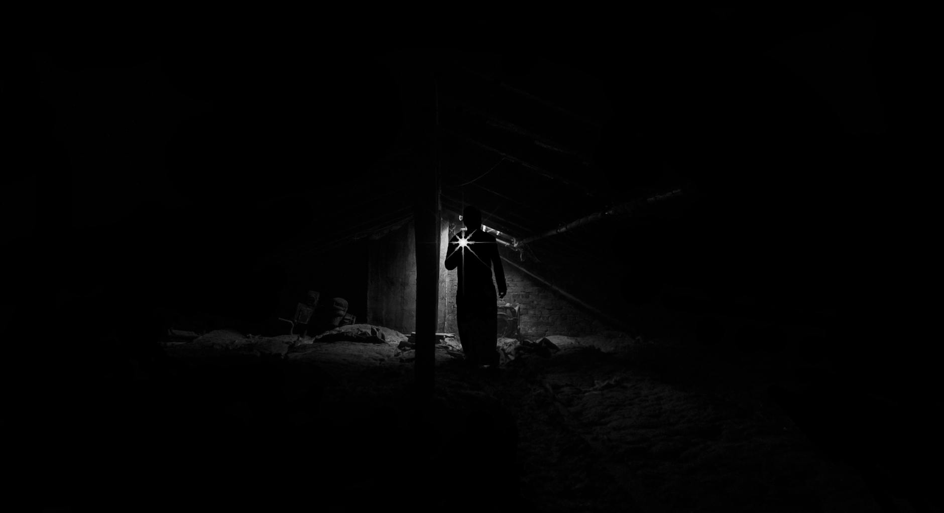 Power Outage Survival - Flashlight and Emergency Lighting Person using a flashlight in a dark room during a power outage