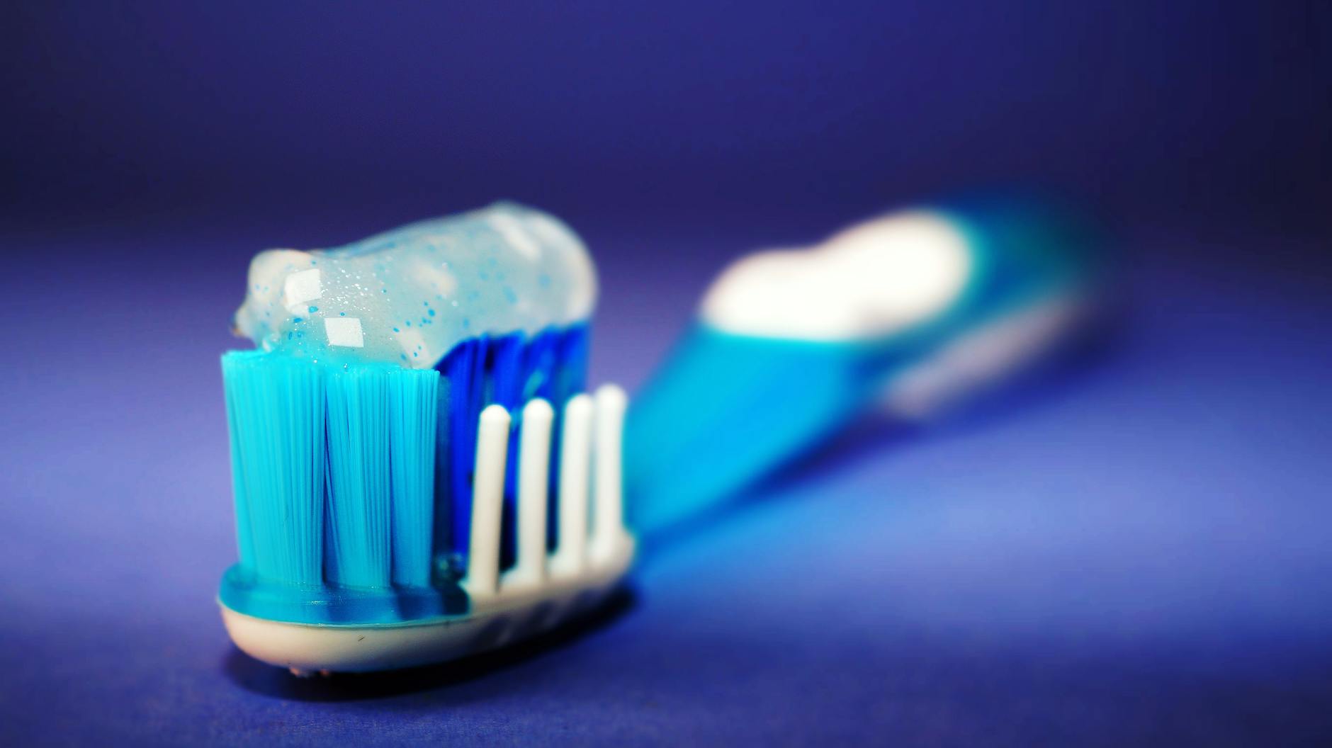 Daily Dental Care Choices - Fluoride-Free Toothpaste Decision Toothbrush with toothpaste representing the daily dental care decision