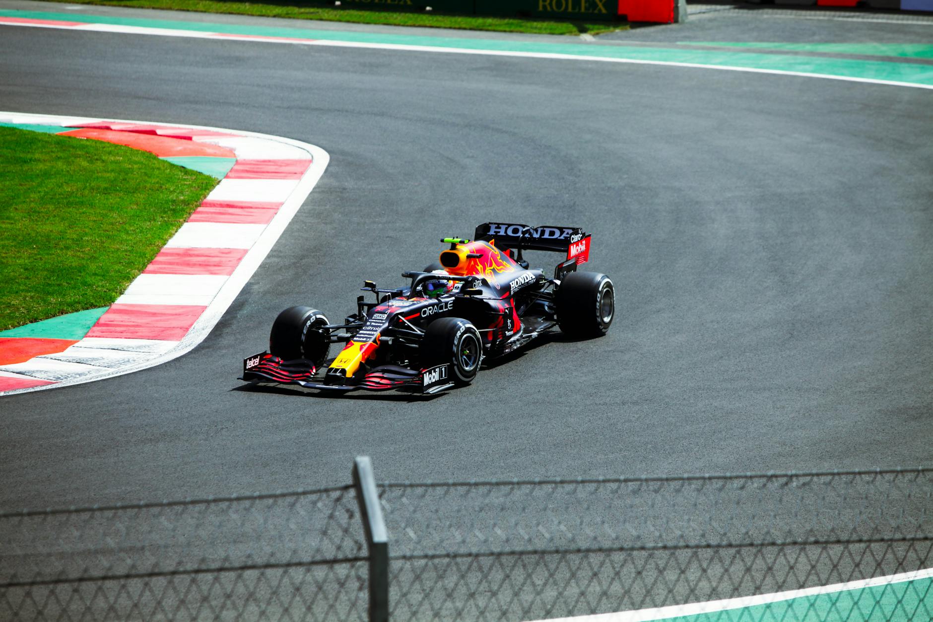 Formula One Racing at the Grand Prix Circuit Formula One car racing at high speed through a grand prix circuit corner