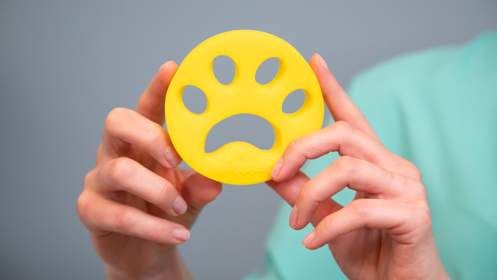 FurZapper In-Use Lifestyle Shot - Pet Hair Collected During Wash Cycle FurZapper being used in a laundry load with pet hair visibly collected on the disc surface