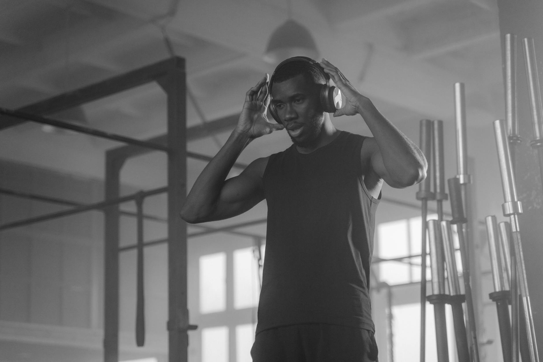 Wireless Earbuds Gym Tech Essentials 2026 Athlete wearing headphones at the gym during a workout session