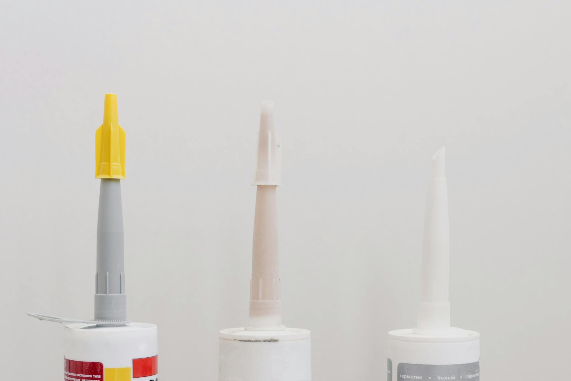 Choosing the Right Adhesive for Plastic Repair Various adhesive and glue tubes laid out for repair work, including different types suitable for plastic bonding