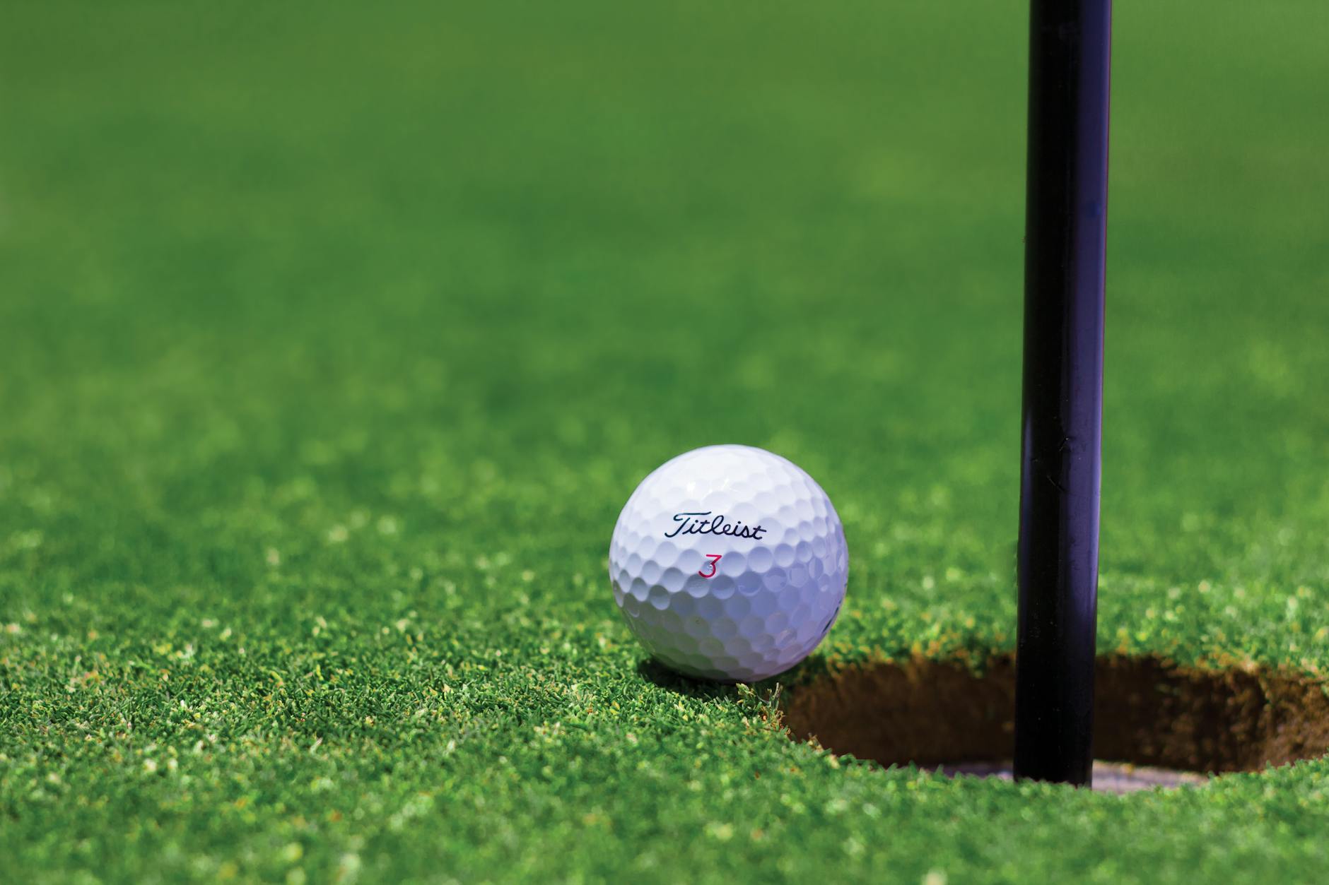 Reading the Break Around the Hole Golf ball resting near the hole on a well-manicured putting green