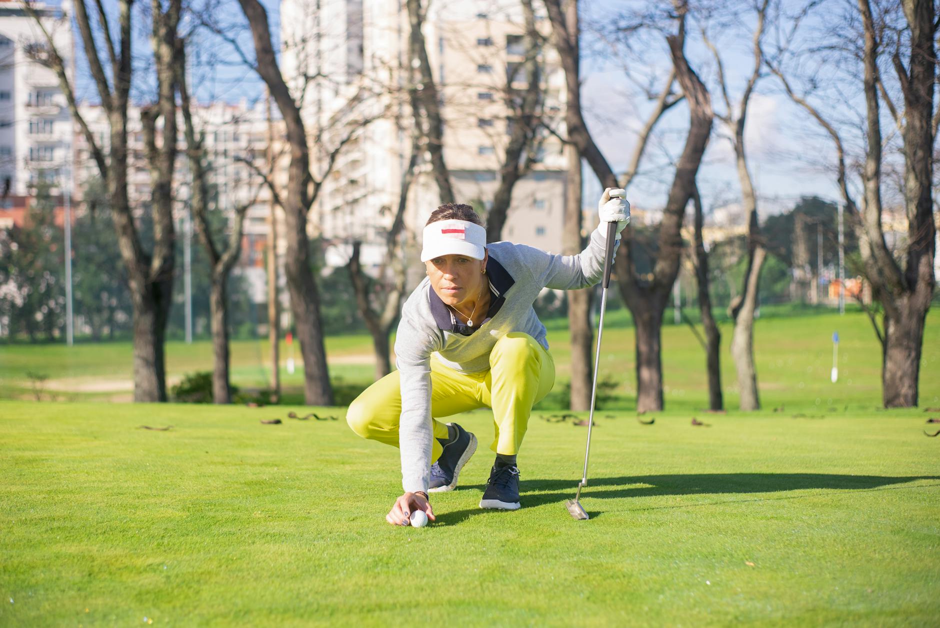 Pre-Putt Focus and Green Reading Routine Woman golfer focusing carefully before making a putt on a sunny golf course