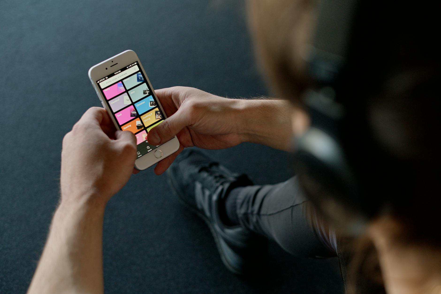 Streaming Music Playlist on Smartphone at the Gym Person checking smartphone with music streaming playlist running at the gym