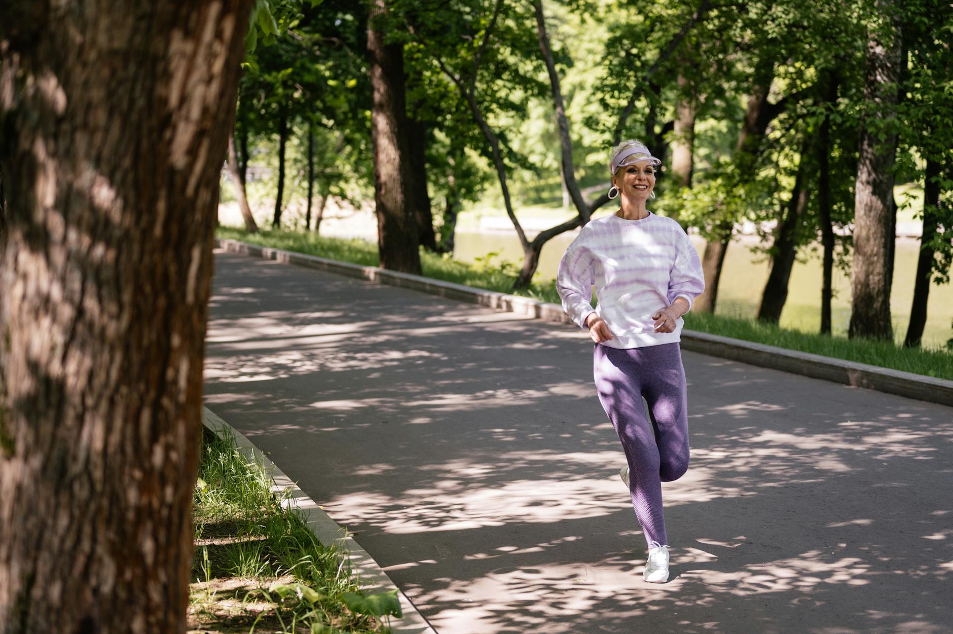 Regular low-impact exercise helps seniors reduce leg swelling naturally Elderly woman jogging in a park to maintain leg circulation and prevent swelling