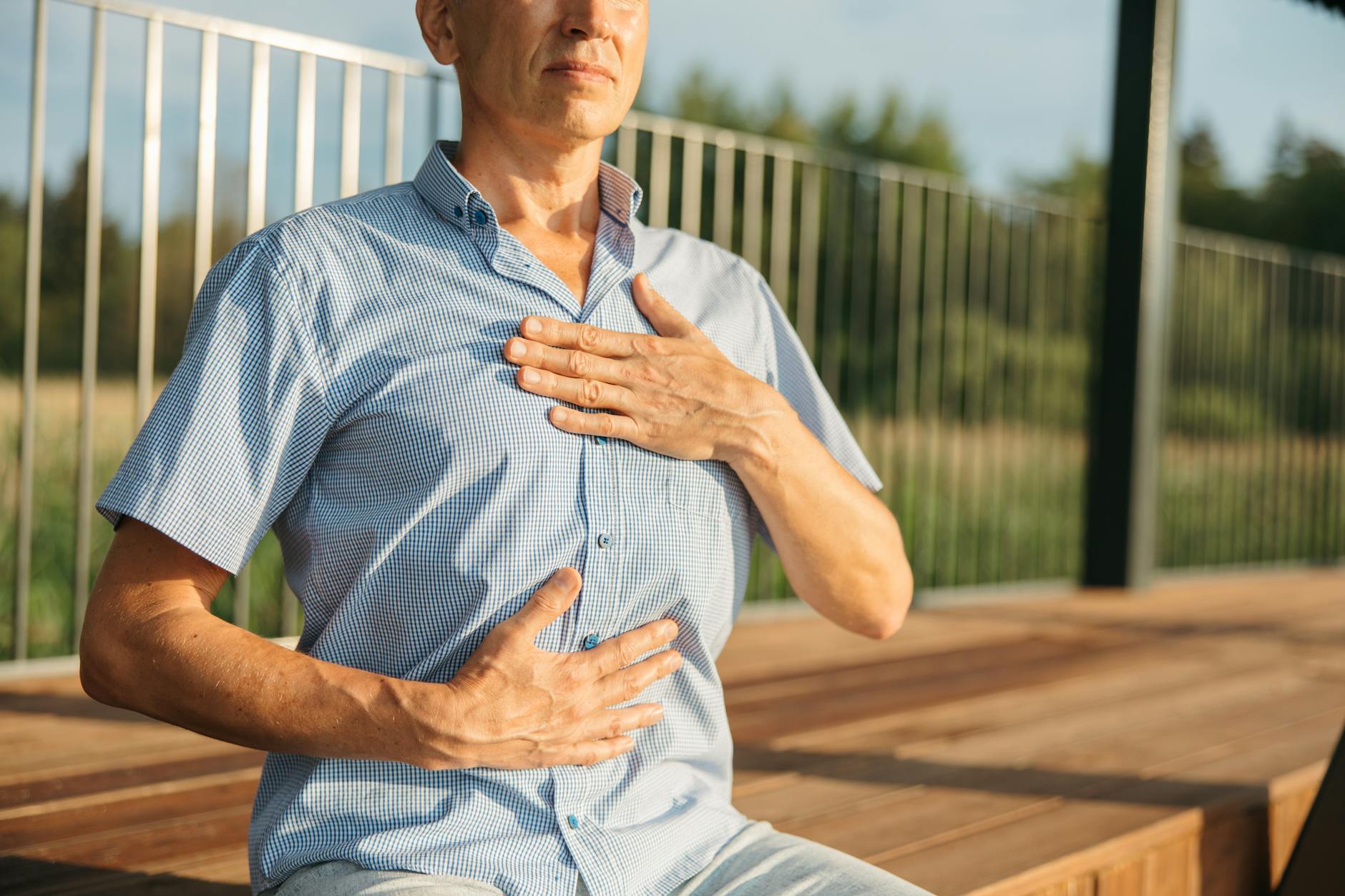 Deep Breathing Exercises for Lung Recovery After Quitting Smoking Man practicing deep breathing with hands on chest, a key exercise for lung recovery after quitting smoking
