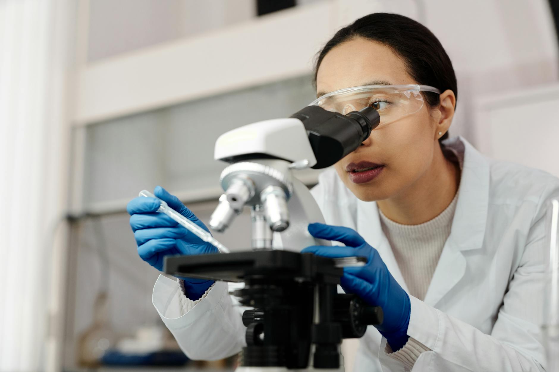 Hydroxyapatite Enamel Repair Science - Laboratory Research Scientist examining dental samples under a microscope in a research laboratory studying hydroxyapatite enamel repair