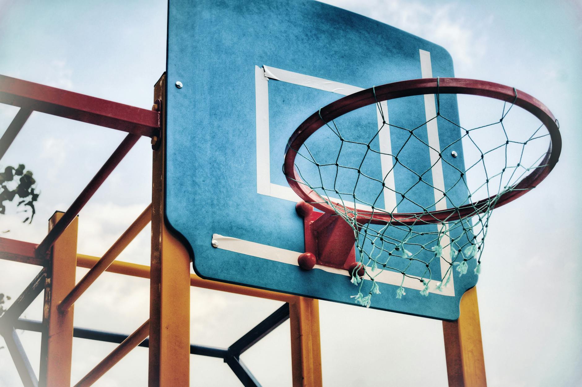 Photography at Basketball Games 2026 Basketball hoop viewed from below against a blue sky