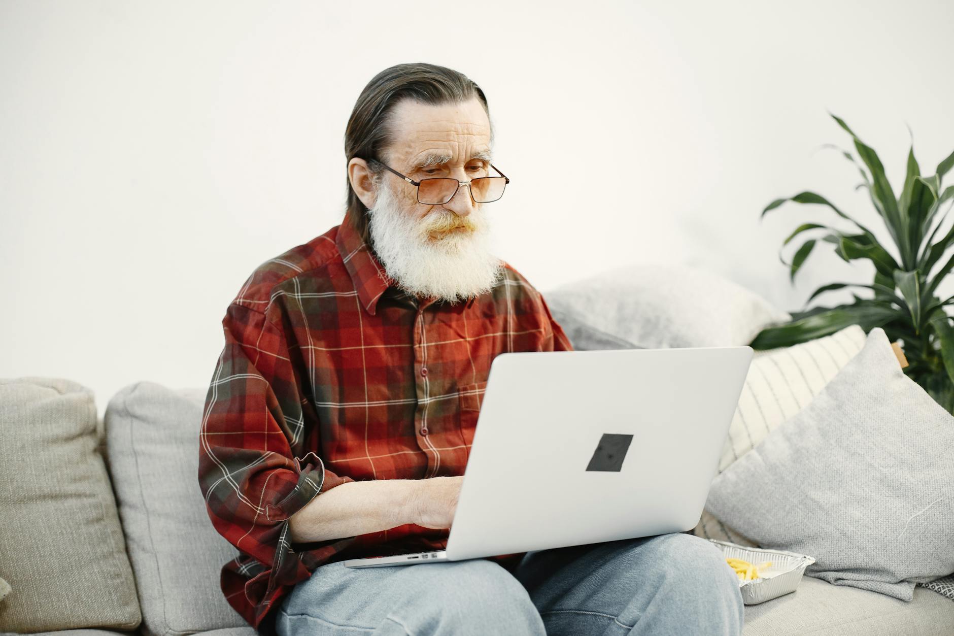 Everyday Internet Users Are Prime Phishing Targets 2026 Older man using a laptop at home, representing everyday internet users targeted by phishing scams