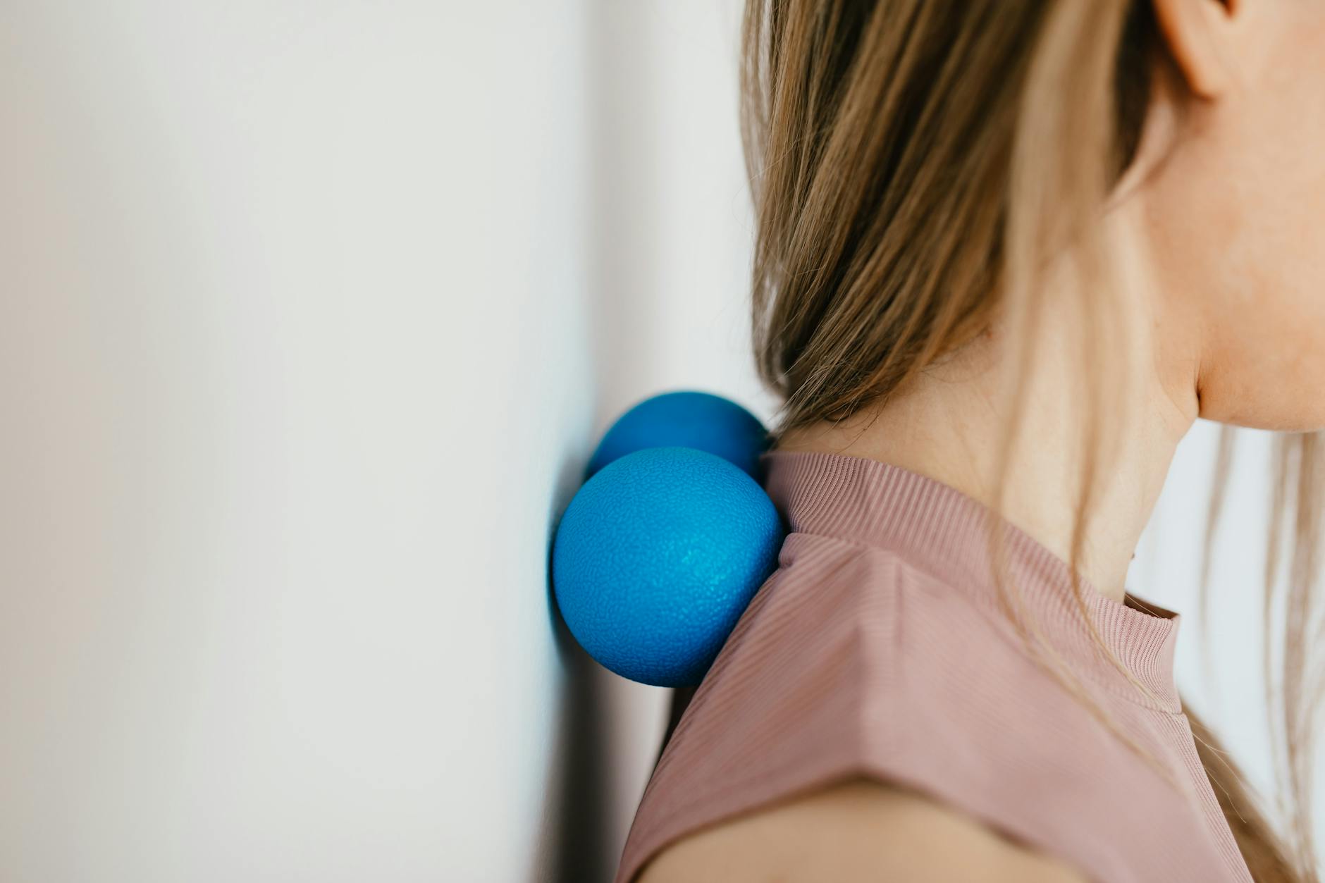 Massage Tools for Muscle Soreness Relief Woman using massage balls on her neck and shoulders to relieve muscle soreness
