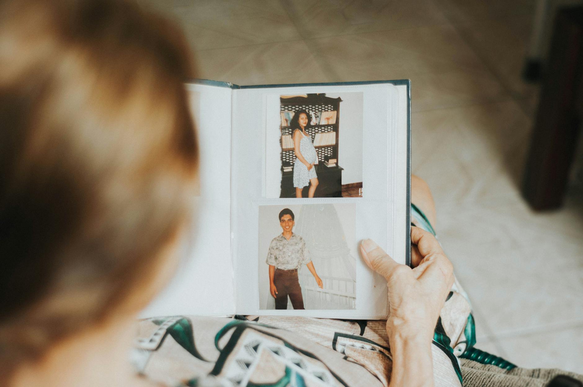Connecting Generations Through Family Photos and History Senior woman looking through a photo album — connecting generations through shared family history and photographs