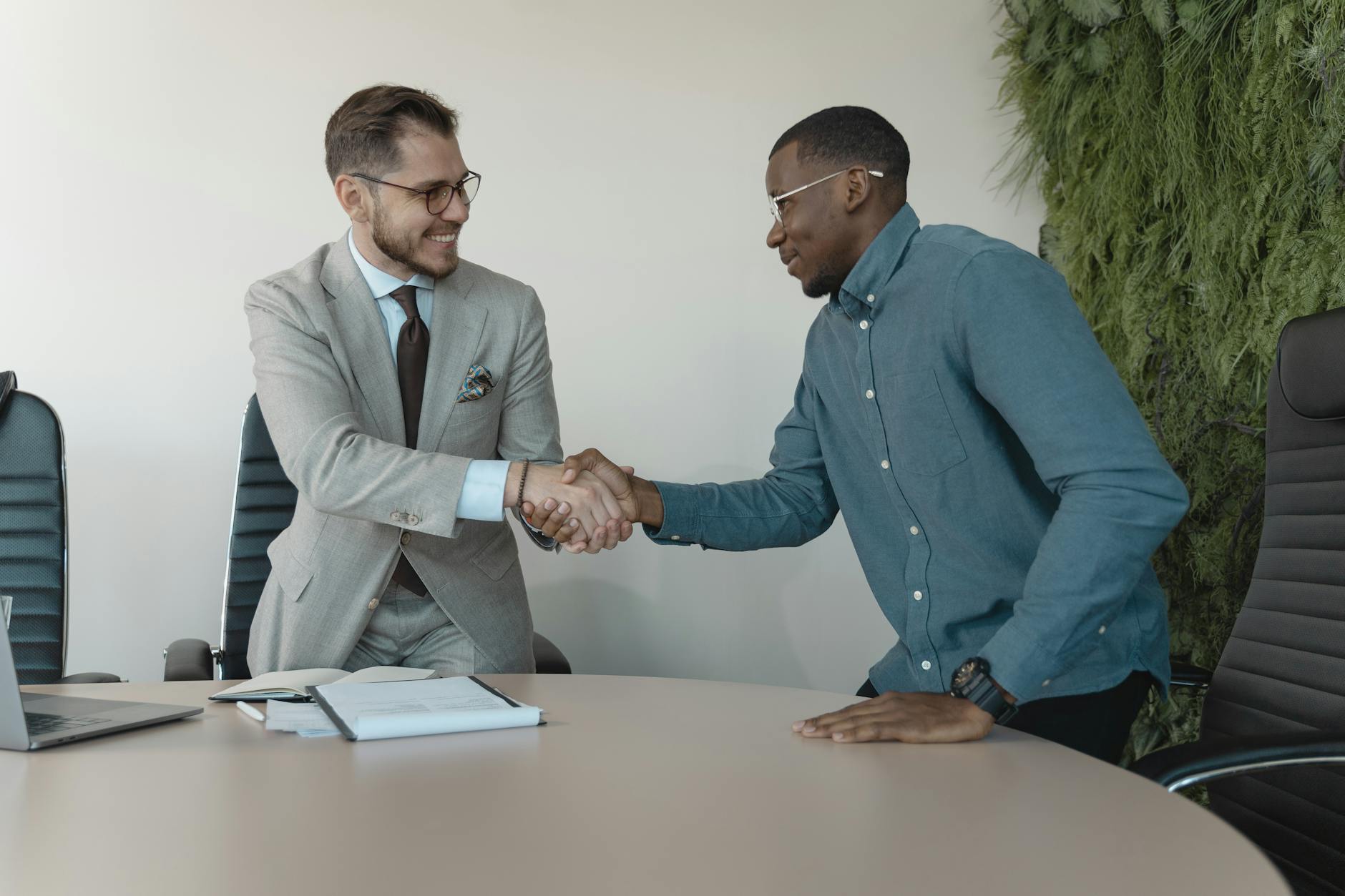 Smile Confidence and Career Success — First Impressions in the Workplace Two professionals shaking hands after a successful job interview, illustrating how smile confidence psychology affects career outcomes