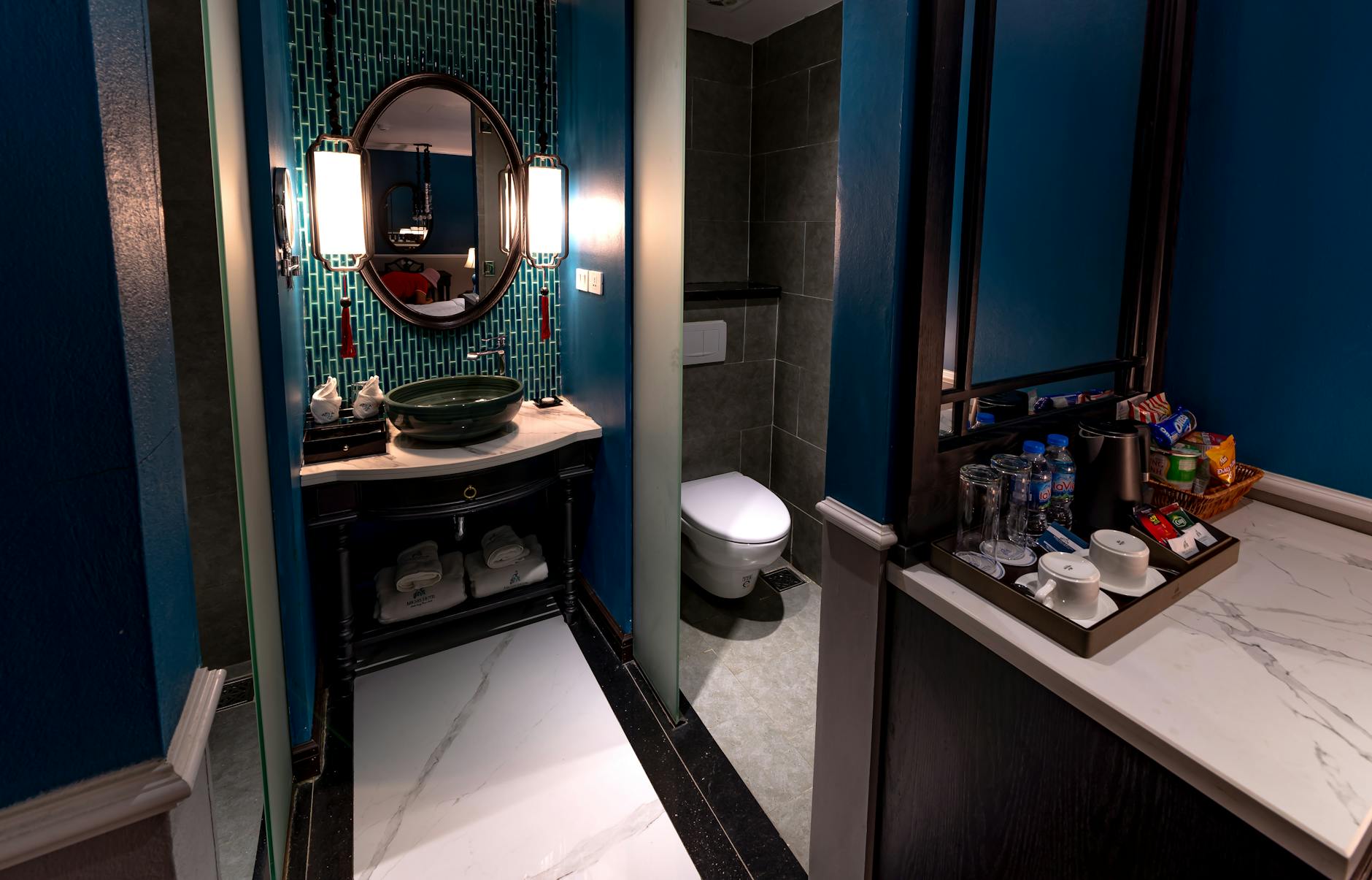 Hotel Bathroom Hygiene Risks While Traveling Modern hotel bathroom with blue walls and contemporary fixtures, illustrating typical travel hygiene risks