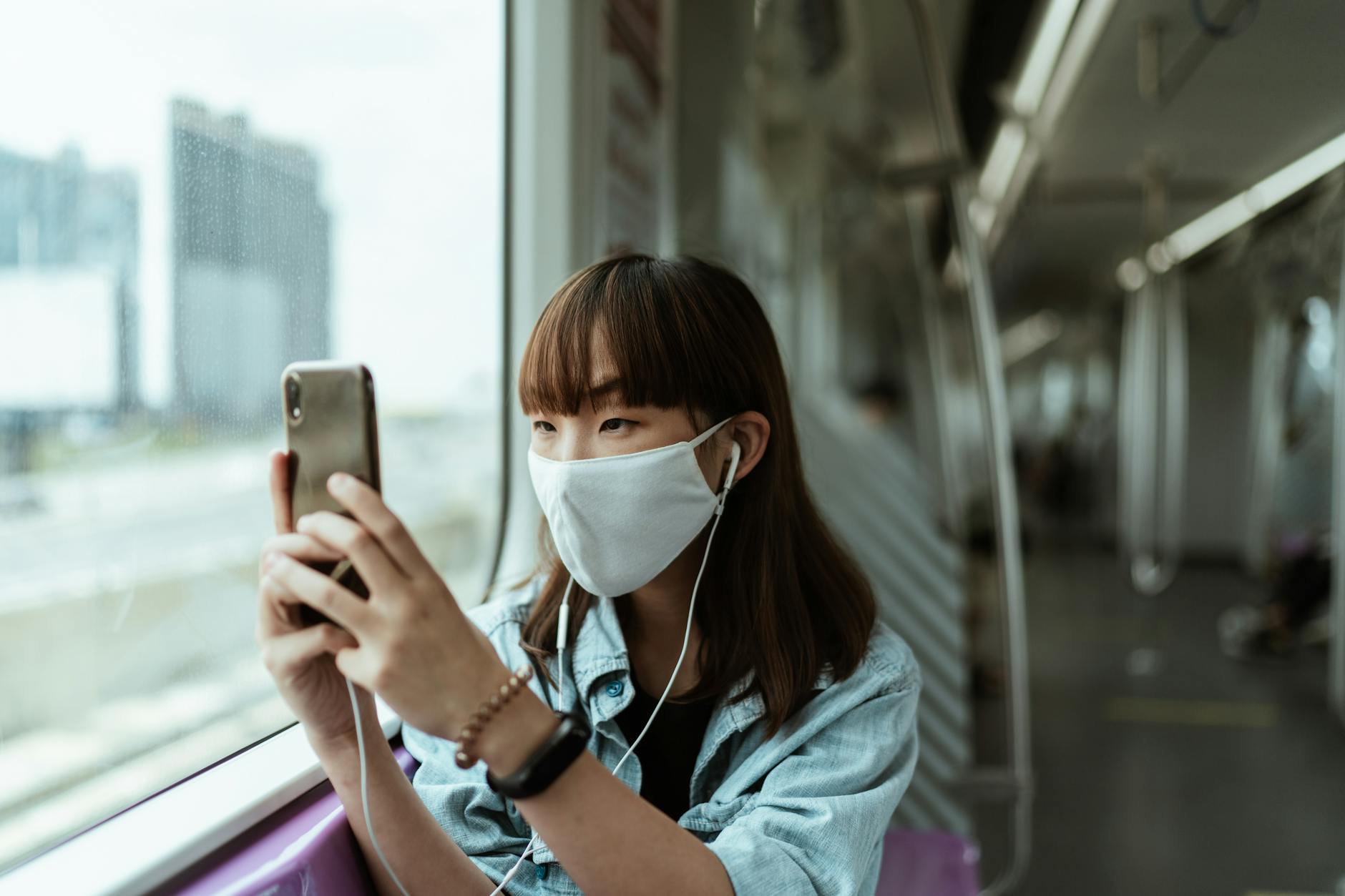 Travel Tech Essentials 2026 - Smartphone as Primary Travel Tool Woman using smartphone while traveling on public transit