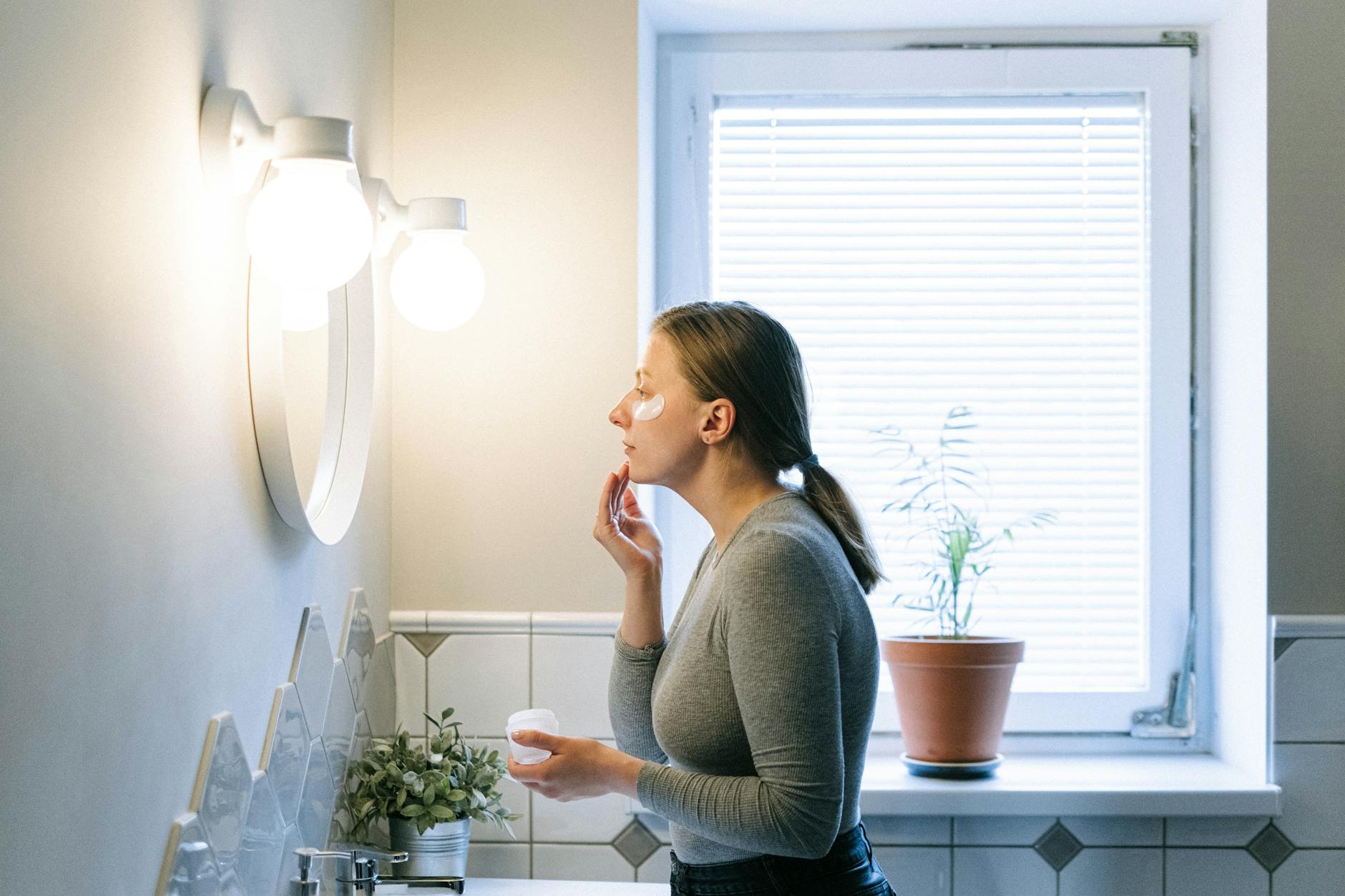 Post-Hair-Removal Skincare Routine for Upper Lip 2026 Woman applying soothing face cream in a bathroom after upper lip hair removal