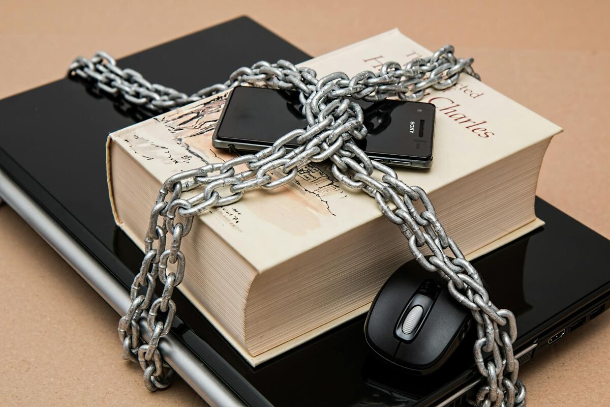 Digital Security and Personal Information Protection Chain-locked book, phone, and laptop symbolizing the importance of securing personal digital information