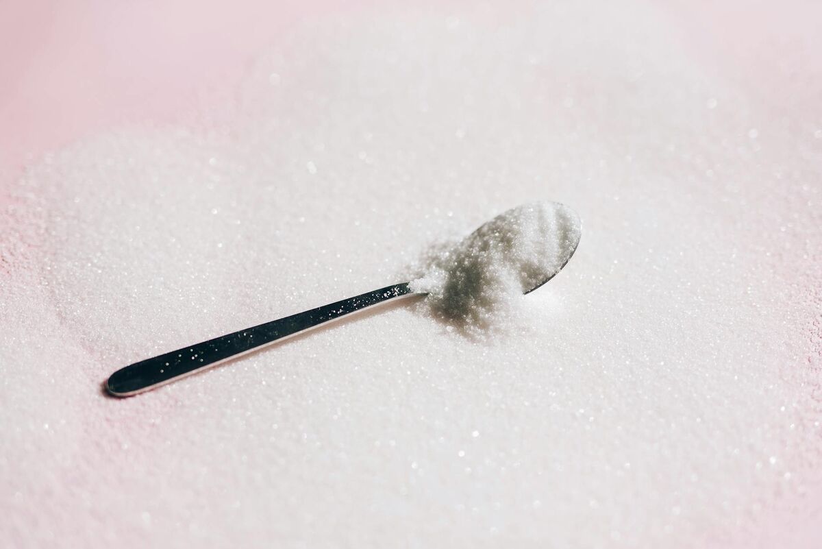 Xylitol looks and tastes like sugar but has a fundamentally different molecular structure White spoon with sugar-like white powder representing xylitol sweetener