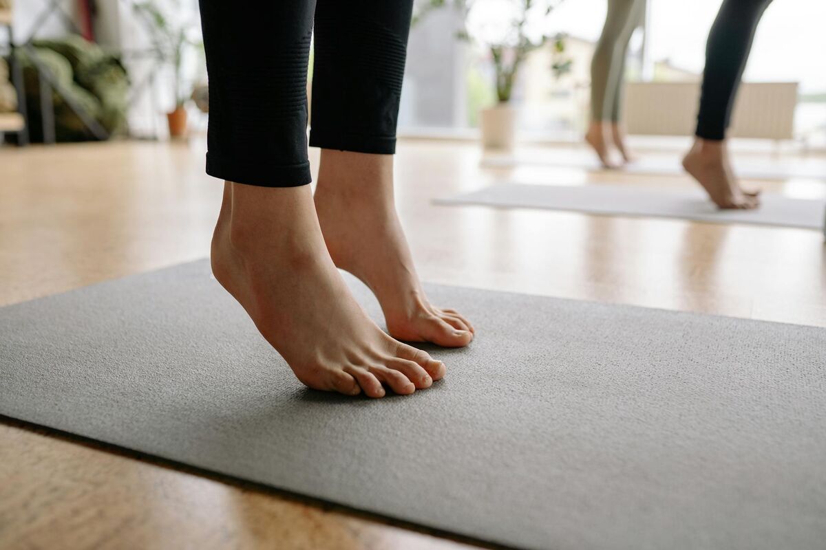 Barefoot Yoga Practice for Foot Strength and Pain Relief Close-up of bare feet during a yoga session, showing mindful foot placement on a mat
